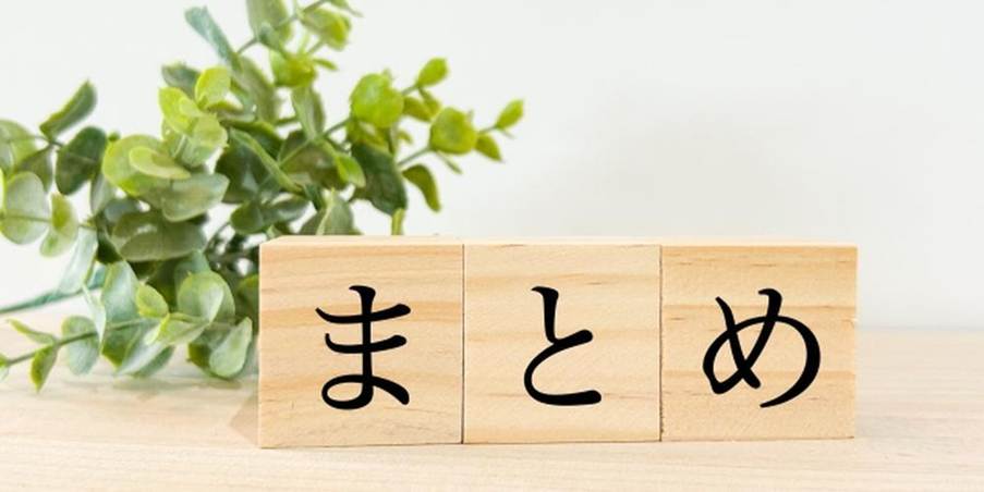 『まとめ』と書かれた木のブロックと観葉植物の装飾