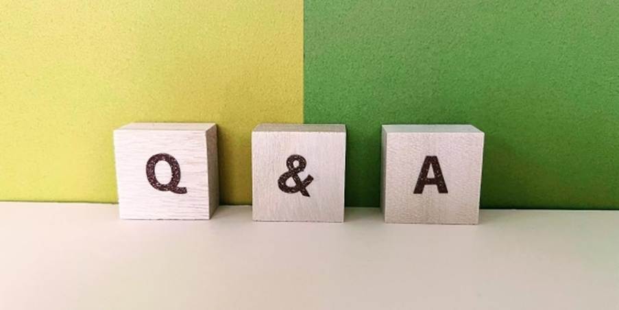 「Q & A」と書かれた木のブロック、緑系の背景