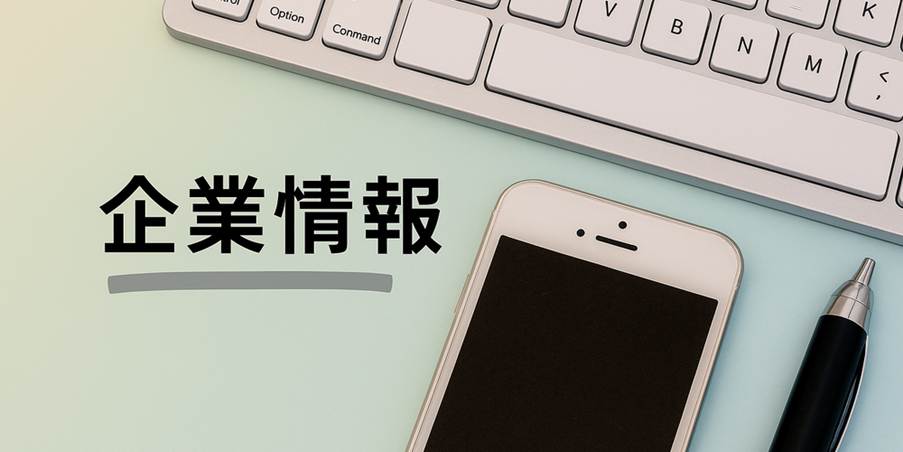 企業情報という文字と、スマートフォン・キーボード・ペンが整然と並ぶデスクの写真